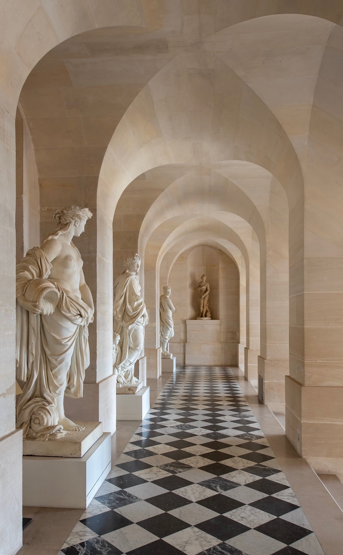 Woman walking through a grand hallway at Versailles